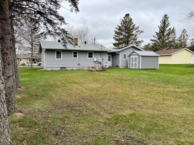 back of property with a lawn, an outbuilding, and a storage unit
