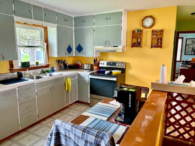kitchen featuring a sink, light floors, light countertops, under cabinet range hood, and electric stove