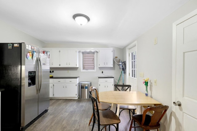 451 Taylor St NE, Minneapolis, MN 55413 - kitchen featuring stainless steel refrigerator with ice dispenser, wood finished floors, white cabinets, dark countertops, and vaulted ceiling