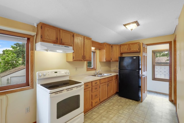 451 Taylor St NE, Minneapolis, MN 55413 - kitchen featuring electric stove, under cabinet range hood, freestanding refrigerator, light countertops, and healthy amount of natural light