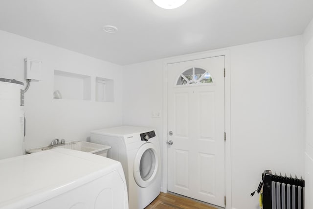 451 Taylor St NE, Minneapolis, MN 55413 - laundry area with radiator heating unit, washer and dryer, and light wood-type flooring