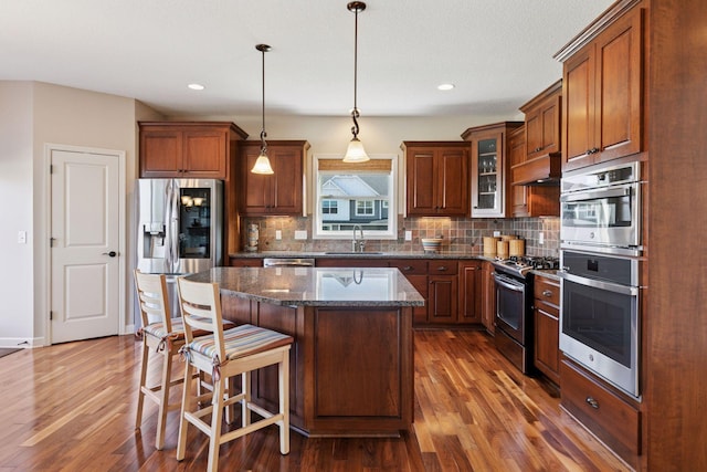 3626 Springwood Ct, Eagan, MN 55123 - kitchen with appliances with stainless steel finishes, a sink, dark wood-style flooring, custom exhaust hood, and a kitchen island