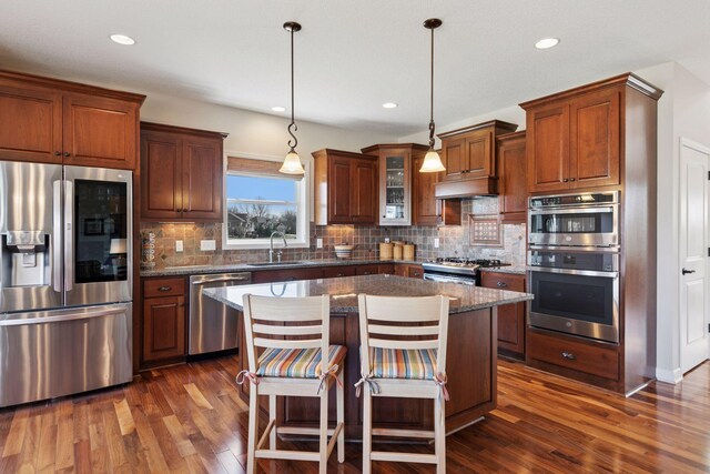 3626 Springwood Ct, Eagan, MN 55123 - kitchen featuring stainless steel appliances, dark wood-style floors, decorative backsplash, a kitchen island, and recessed lighting