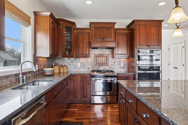3626 Springwood Ct, Eagan, MN 55123 - kitchen featuring stainless steel appliances, a sink, dark wood-type flooring, hanging light fixtures, and glass insert cabinets