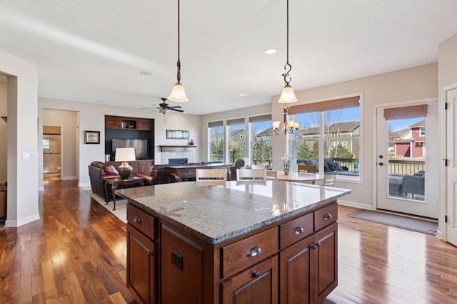 3626 Springwood Ct, Eagan, MN 55123 - kitchen featuring a fireplace, wood-type flooring, a ceiling fan, baseboards, and a center island