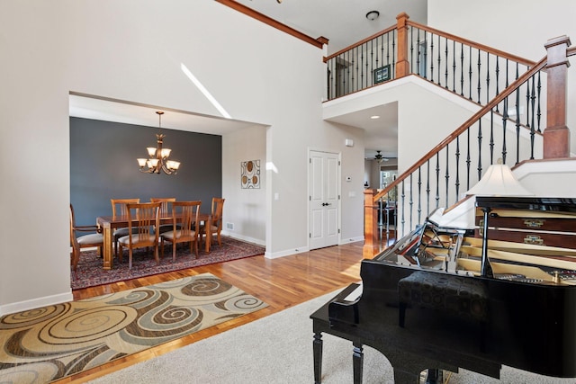 3626 Springwood Ct, Eagan, MN 55123 - living room featuring wood finished floors, a chandelier, baseboards, a high ceiling, and stairs