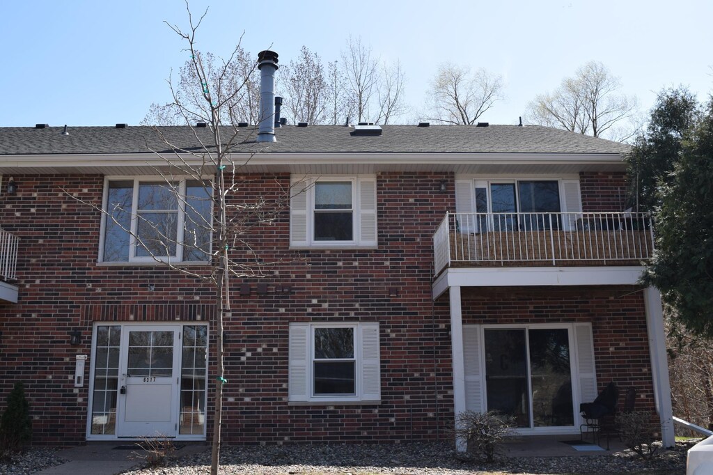 6317 Alderwood Unit G, Woodbury, MN 55125 - rear view of house with brick siding, a balcony, and a patio