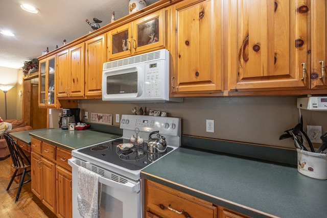 2475 44th St SW, Pine River, MN 56474 - kitchen with brown cabinets, white appliances, and glass insert cabinets
