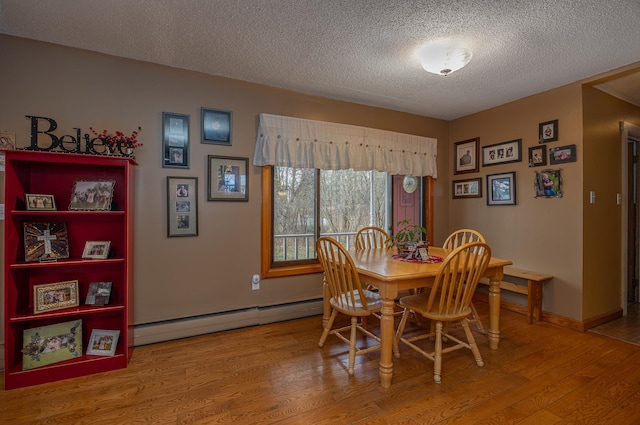 2475 44th St SW, Pine River, MN 56474 - dining space featuring a baseboard heating unit, a textured ceiling, and wood finished floors