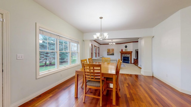 1213 Grey Fox Ave SW, Rochester, MN 55902 - dining area featuring wood finished floors, a chandelier, baseboards, and a tile fireplace