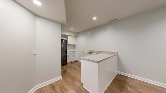 1213 Grey Fox Ave SW, Rochester, MN 55902 - kitchen featuring freestanding refrigerator, a peninsula, light wood finished floors, baseboards, and light countertops