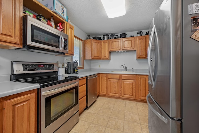 1601 5th Ave, Grand Rapids, MN 55744 - kitchen featuring a textured ceiling, appliances with stainless steel finishes, light countertops, and a sink