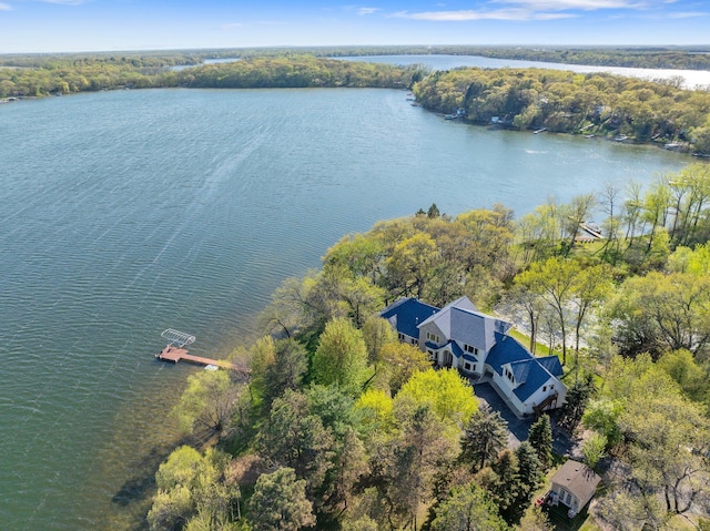 view of subject property with a nearby body of water and a heavily wooded area