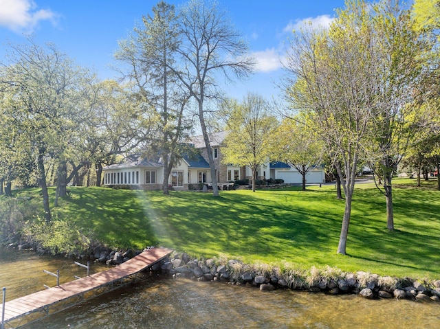 view of grassy yard featuring a boat dock