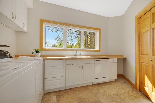 clothes washing area featuring washing machine and clothes dryer, a sink, and light stone finish flooring