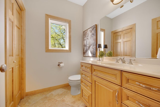 bathroom featuring toilet, vanity, tile patterned flooring, and baseboards