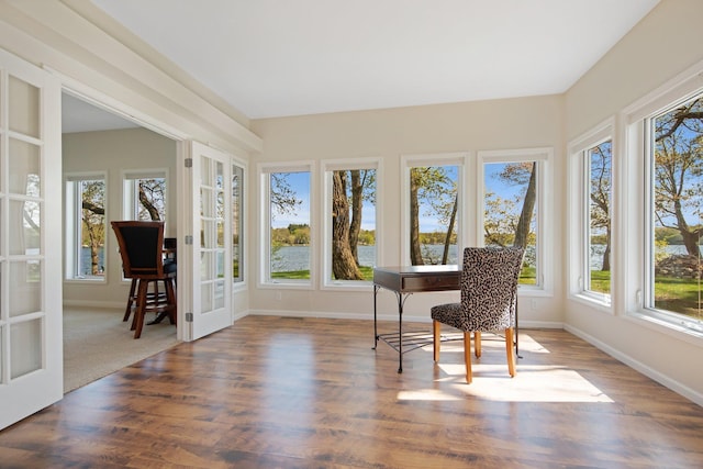 sunroom featuring french doors, wood finished floors, and baseboards