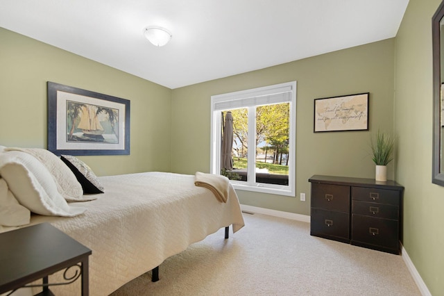 bedroom featuring baseboards and light carpet