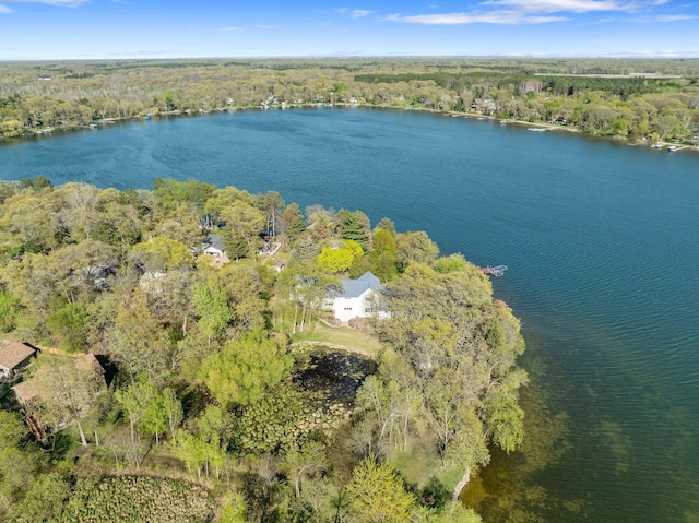 aerial view of property's location with a heavily wooded area and a nearby body of water