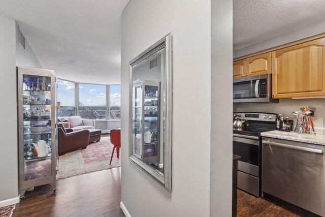1425 28th St Unit 407, Minneapolis, MN 55408 - kitchen featuring stainless steel appliances, dark wood finished floors, a textured ceiling, light brown cabinets, and open floor plan