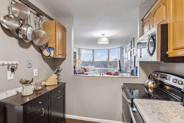 1425 28th St Unit 407, Minneapolis, MN 55408 - kitchen featuring stainless steel appliances, a textured ceiling, and light countertops