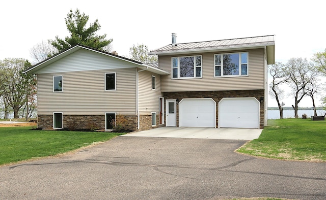44172 Mosquito Heights Rd, Perham, MN 56573 - view of front facade featuring driveway, stone siding, a garage, a front lawn, and a standing seam roof