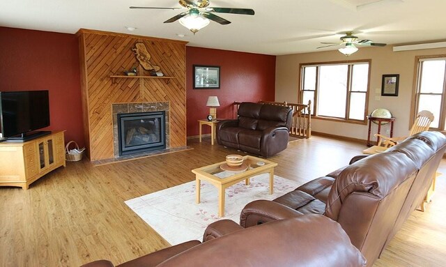 44172 Mosquito Heights Rd, Perham, MN 56573 - living area with ceiling fan, an accent wall, a fireplace with flush hearth, and light wood-style floors