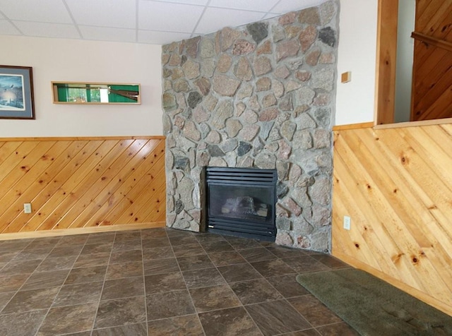 44172 Mosquito Heights Rd, Perham, MN 56573 - unfurnished living room with a drop ceiling, wood walls, baseboards, a wainscoted wall, and a fireplace