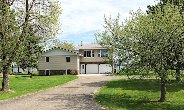 44172 Mosquito Heights Rd, Perham, MN 56573 - tri-level home with asphalt driveway, a garage, a standing seam roof, a front lawn, and metal roof