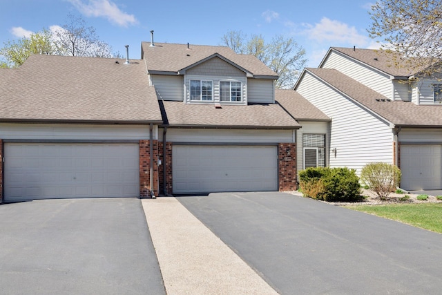 2499 Lockwood Dr Unit 61, Mendota Heights, MN 55120 - view of front facade featuring brick siding, a garage, driveway, and roof with shingles