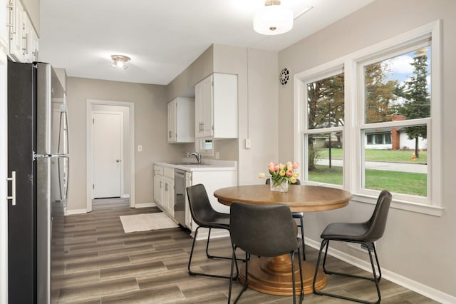 dining space featuring baseboards, plenty of natural light, and wood finished floors