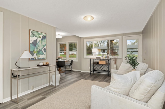 living area with baseboards and wood finished floors