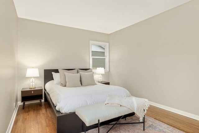 bedroom with baseboards and wood finished floors
