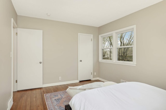 bedroom with baseboards and wood finished floors