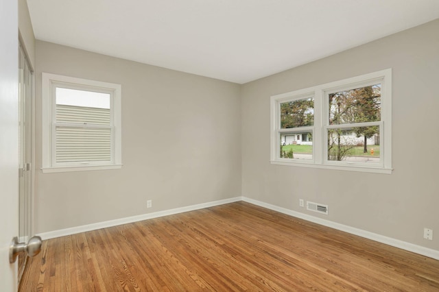 unfurnished room with baseboards, light wood-style flooring, and visible vents