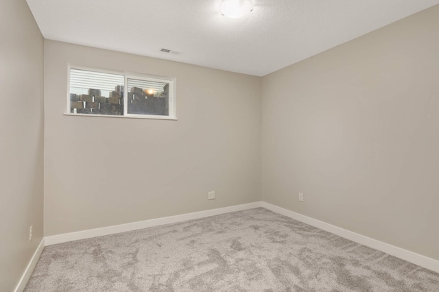 spare room with visible vents, carpet, and baseboards