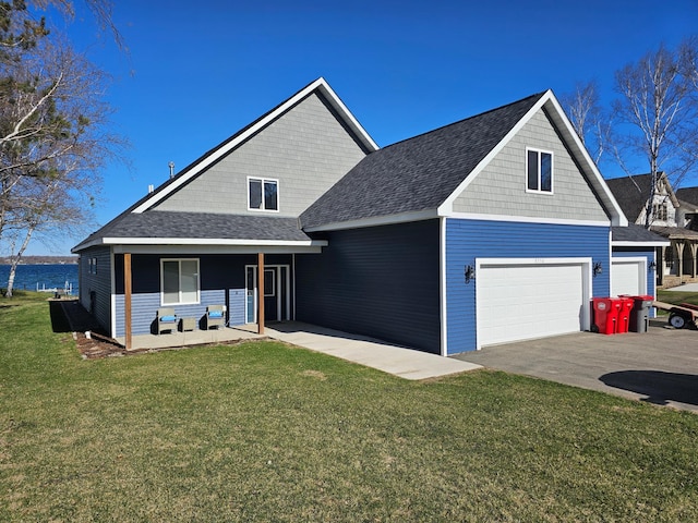 view of front of property featuring a front yard, a shingled roof, driveway, and a porch