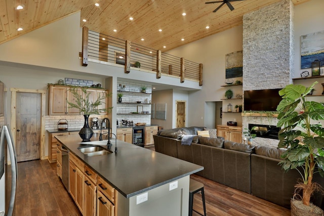kitchen with a sink, dark countertops, high vaulted ceiling, wooden ceiling, and open floor plan