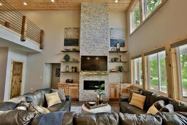 living room featuring wooden ceiling, a high ceiling, dark wood-style floors, a fireplace, and recessed lighting