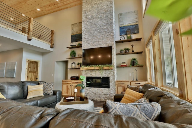 living area with a towering ceiling, wooden ceiling, a fireplace, wood finished floors, and recessed lighting