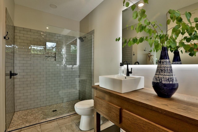 full bathroom featuring a stall shower, toilet, and vanity