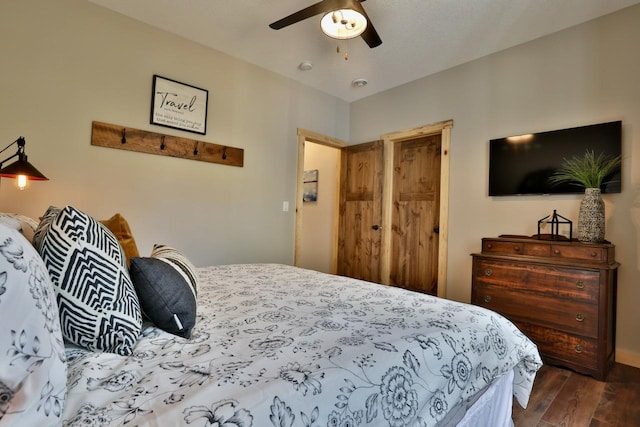 bedroom with dark wood-style floors, ceiling fan, and baseboards