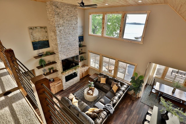 living room featuring wooden ceiling, dark wood-style flooring, a fireplace, a ceiling fan, and lofted ceiling