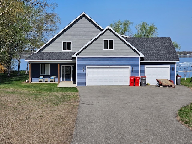 view of front of property featuring driveway, a front yard, a porch, a garage, and roof with shingles