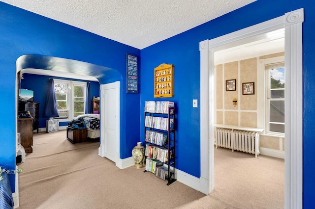 1102 Pacific St, Saint Paul, MN 55106 - corridor with radiator heating unit, carpet flooring, baseboards, a textured ceiling, and cooling unit