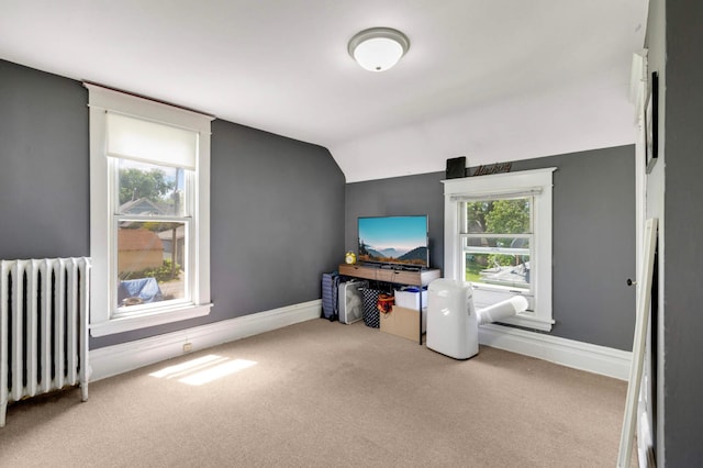 1102 Pacific St, Saint Paul, MN 55106 - unfurnished living room with radiator, carpet flooring, lofted ceiling, and baseboards