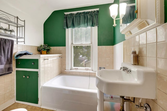 1102 Pacific St, Saint Paul, MN 55106 - full bathroom featuring tile walls, a garden tub, a sink, vaulted ceiling, and tile patterned floors