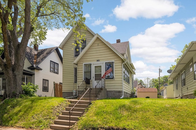 1102 Pacific St, Saint Paul, MN 55106 - view of front of home with a chimney, a front lawn, and roof with shingles