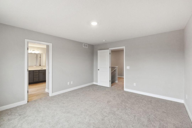 unfurnished bedroom featuring visible vents, baseboards, and light carpet