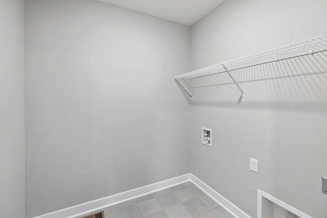 laundry area featuring hookup for an electric dryer, hookup for a washing machine, baseboards, and laundry area